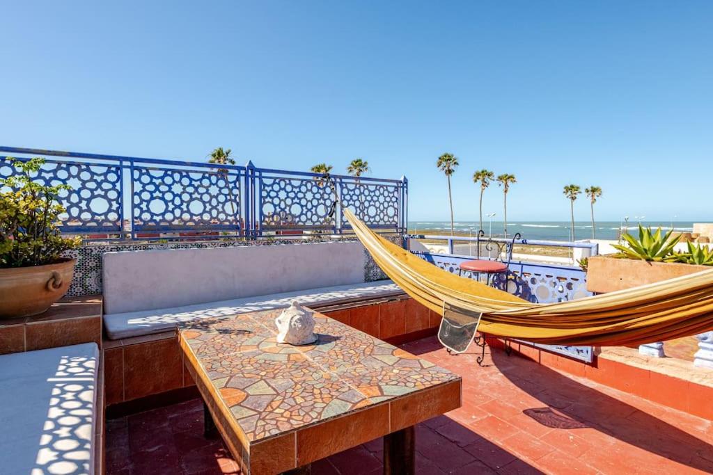d'une terrasse avec un hamac, une table et des chaises. dans l'établissement Dar Statia 3 vue mer, à El Jadida