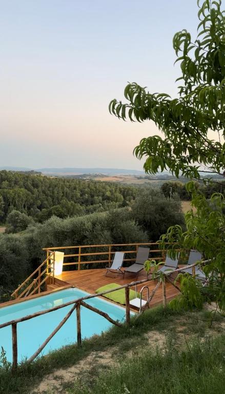 a house with a deck and two chairs and a pool at Casale Nora in Siena