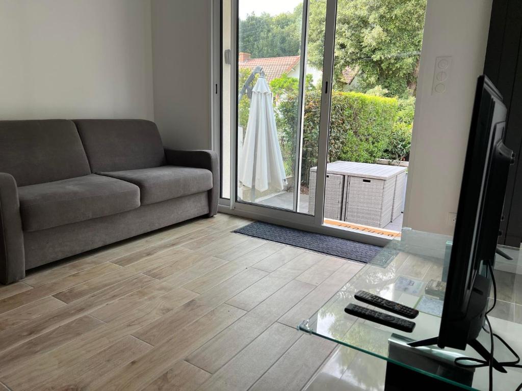 a living room with a couch and a glass table at madeline house's in Mindin