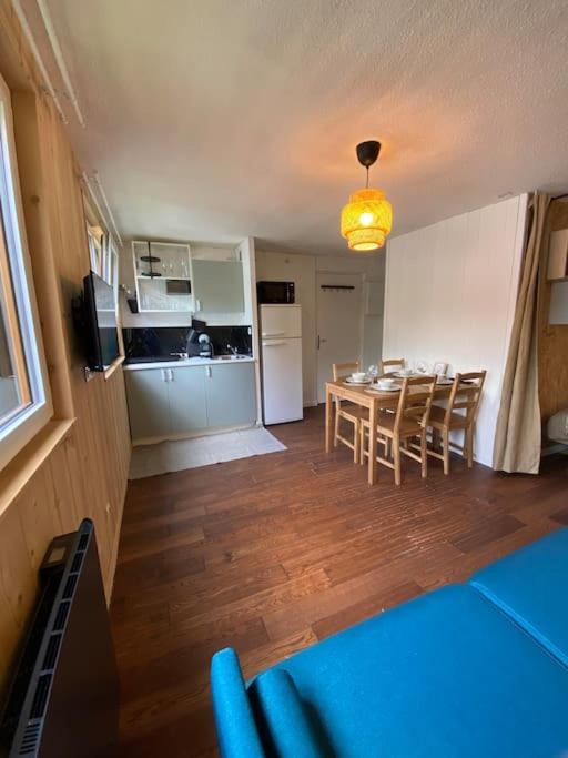 une cuisine et une salle à manger avec une table et des chaises dans l'établissement Studio chaleureux rénové, à Allemont