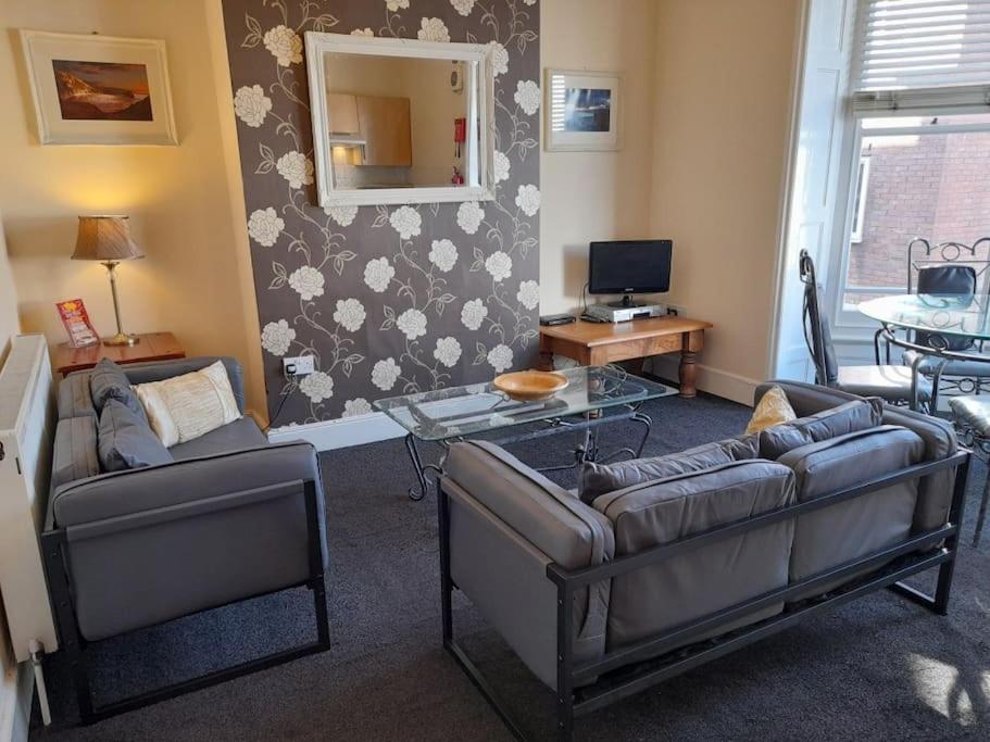 Una sala de estar con dos sofás y una mesa. en Upwey, en Weymouth