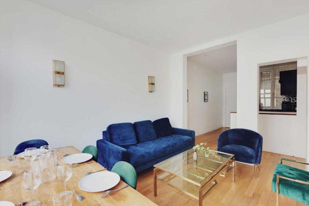 un salon avec un canapé bleu et une table dans l'établissement Luxurious apartment - 3BR-6P - Nation, à Paris