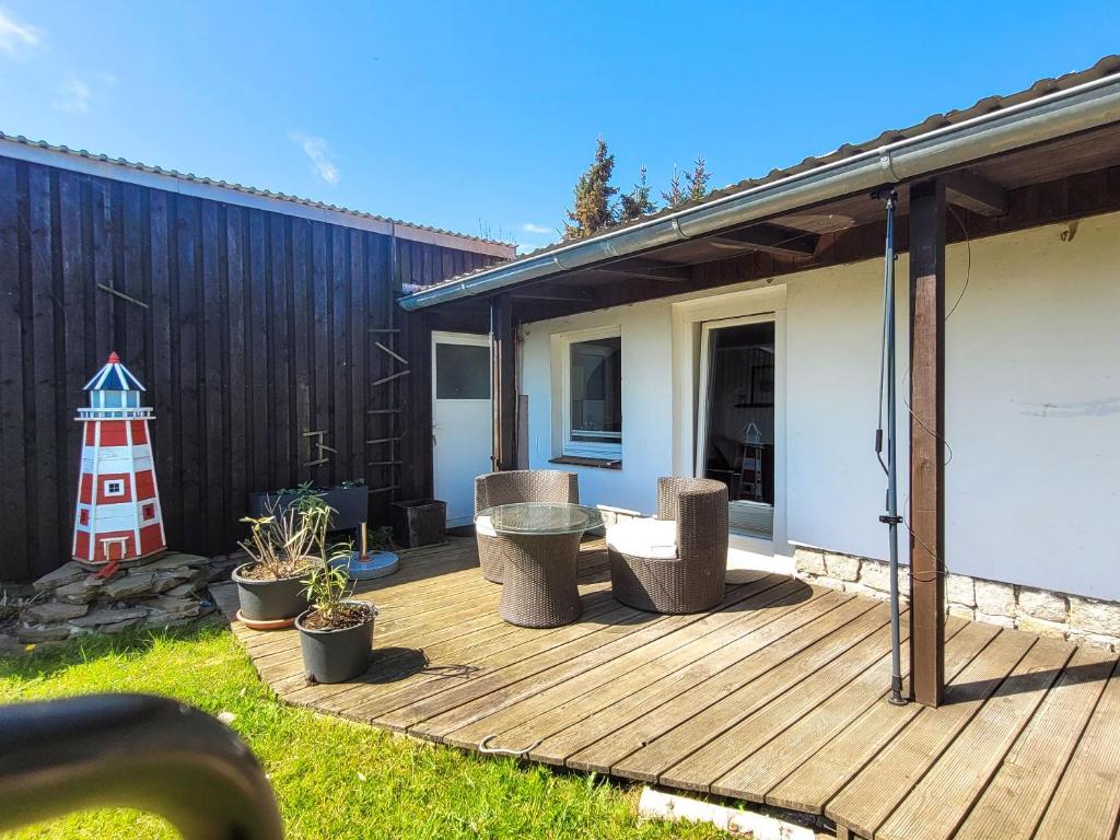 un ponte di legno con un faro in un cortile di Ferienwohnung kleine Koje a Kröslin