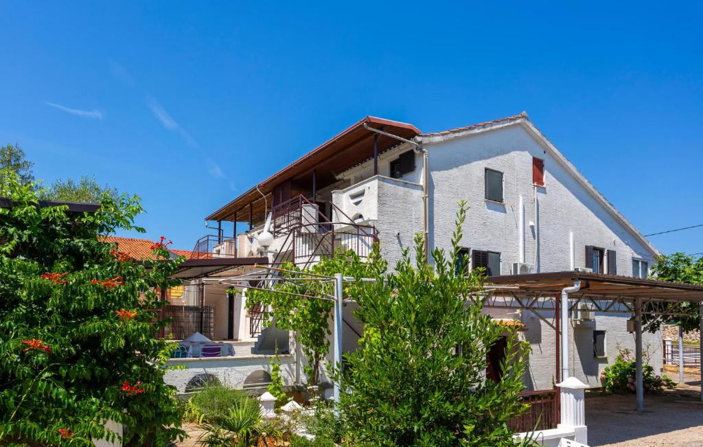 a large white house with a balcony and trees at 2 Bedroom Amazing Apartment In Pinezici in Pinezici
