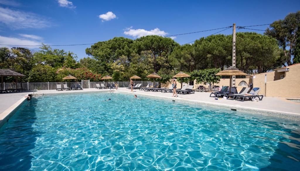 une grande piscine avec des gens dans l'eau dans l'établissement Camping maeva Escapades Le Hameau des Pins, à La Crau