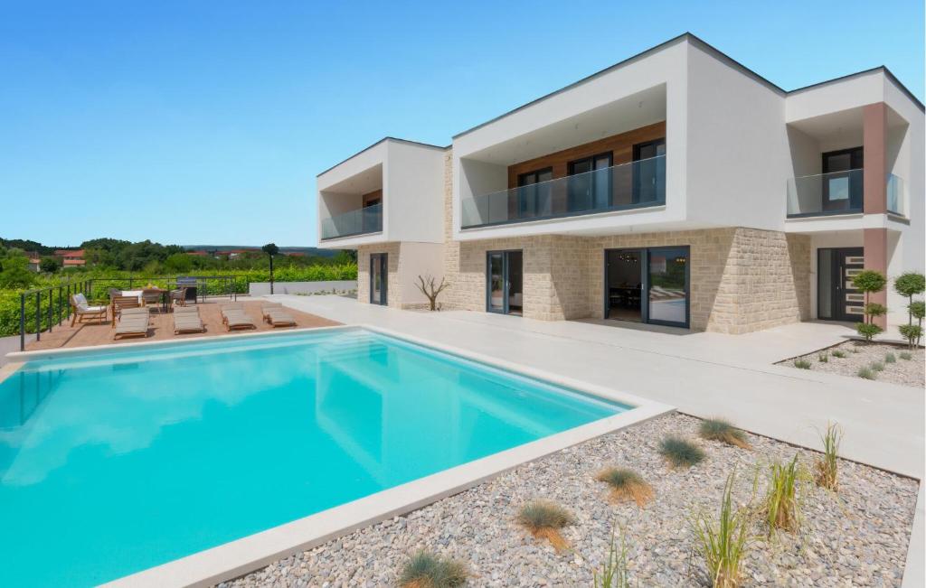 a villa with a swimming pool in front of a house at Cozy Home In Kamen Most in Kamenmost