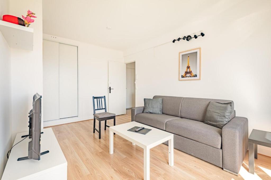 un salon avec un canapé et une table dans l'établissement Southern Paris - Near Metro Line 4, à Bagneux