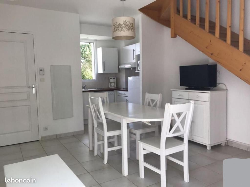 cocina con mesa blanca y sillas blancas en Maison 4-6 personnes, en Saint-Brevin-les-Pins