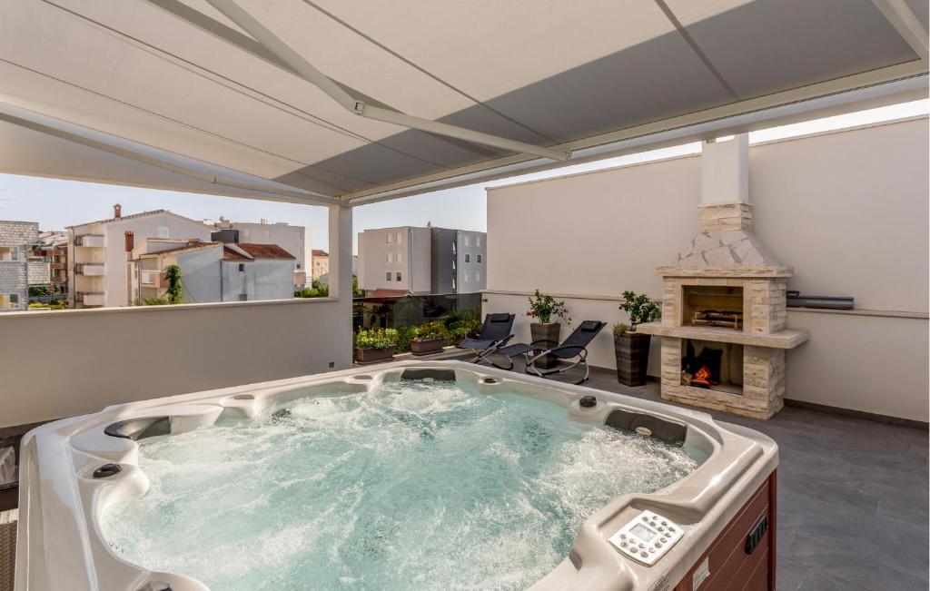 Un jacuzzi en un balcón con chimenea. en Cozy Apartment In Strozanac With Wifi, en Strožanac