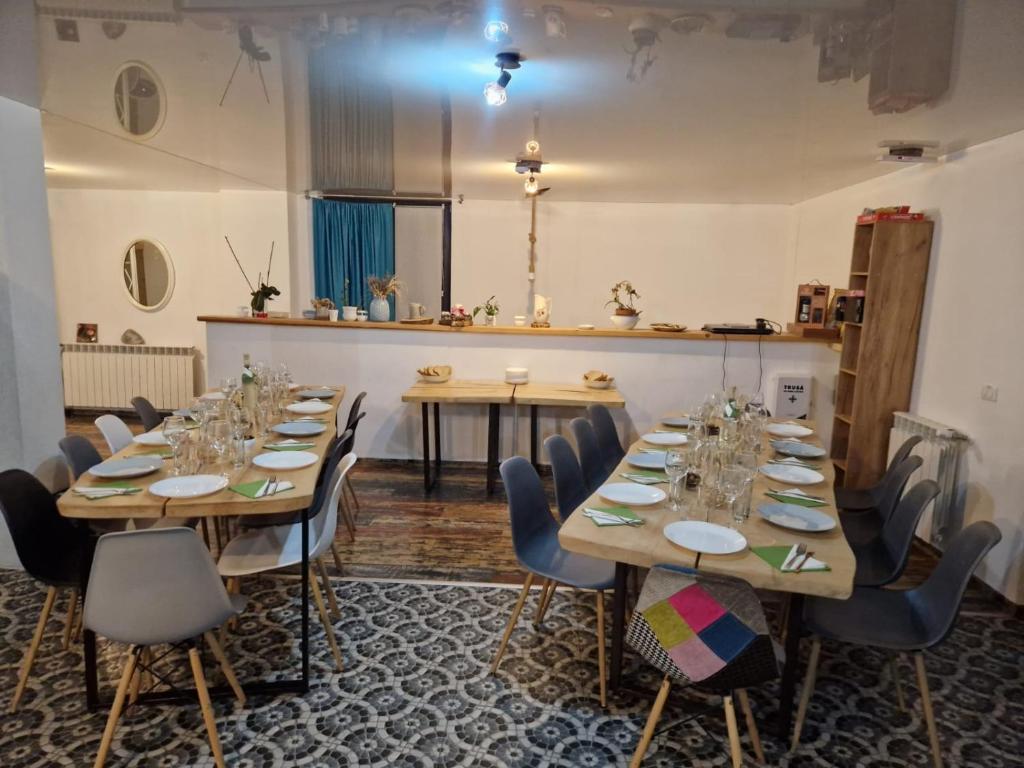 a room with long tables and chairs and a counter at Casa Prieteniei - rezervare integrală in Bistriţa