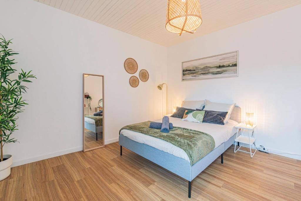 une chambre avec un grand lit et un miroir dans l'établissement L'éclat - Calme et proche gare, à Reims