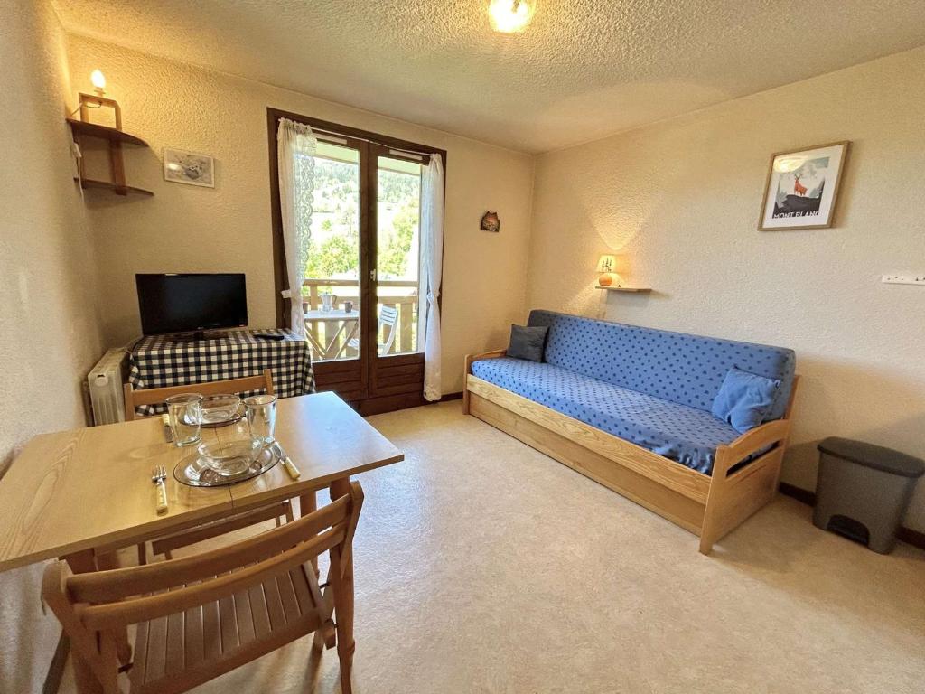 un salon avec un canapé bleu et une table dans l'établissement Studio confortable avec balcon, proche des pistes - 2 couchages à Demi-Quartier - FR-1-597-18, à Demi-Quartier