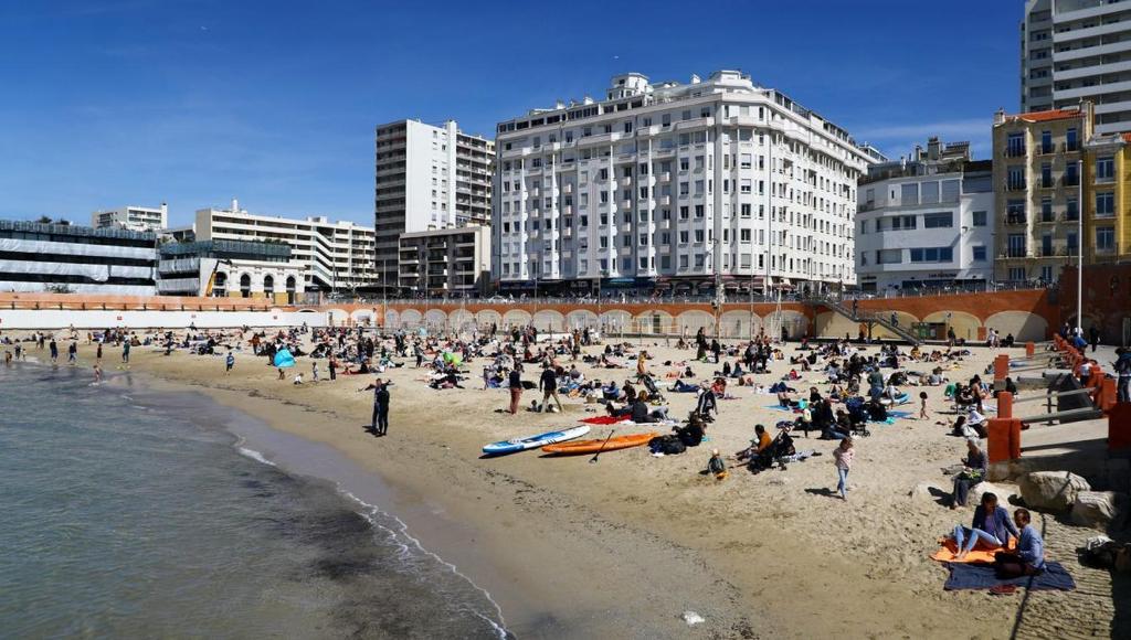 un groupe de personnes sur une plage près de l'eau dans l'établissement Appartement plage Catalan, à Marseille