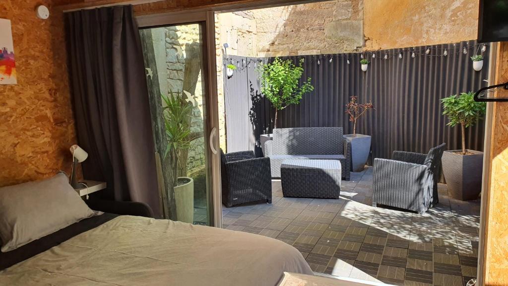 a room with a bed and chairs on a patio at Studio du 44 in Poitiers