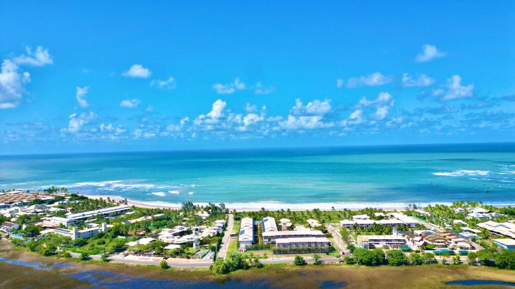 an aerial view of a resort near the ocean at Itacimirim Summer Ville - Pé na areia in Camacari