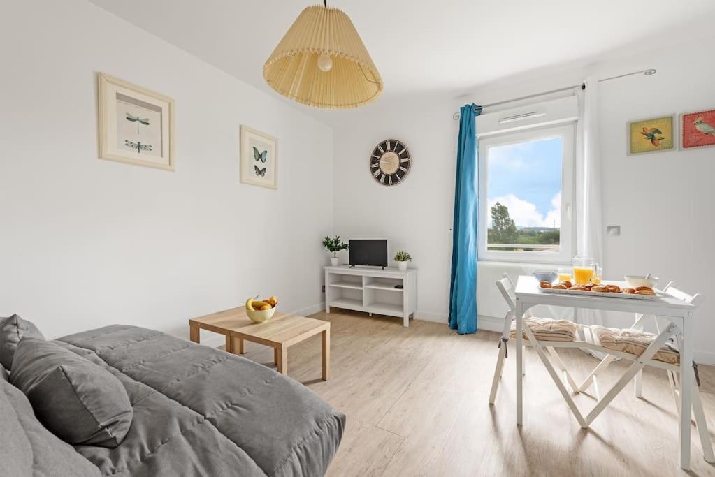 Cette chambre blanche dispose d'un lit, d'une table et d'une fenêtre. dans l'établissement Aurore - Studio 24, à Carcassonne