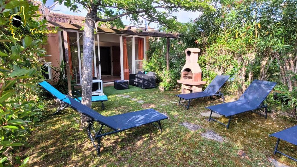 une cour arrière avec des chaises bleues et une balançoire dans l'établissement Duplex Jardin plage de Pinarello à pied, à Pinarellu
