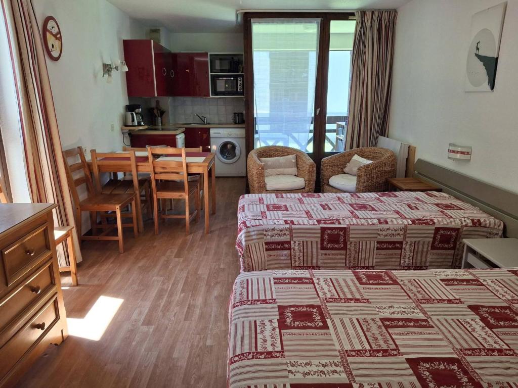 une chambre d'hôtel avec deux lits et une salle à manger dans l'établissement Studio Lumineux 4 Pers. avec Double Exposition, Balcon, Parking et WIFI - Brides-les-Bains - FR-1-512-178, à Brides-les-Bains