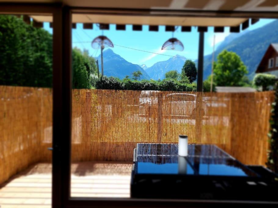 une fenêtre avec vue sur une clôture et des montagnes dans l'établissement Superbe studio à 2 pas du centre, au Bourg-dʼOisans