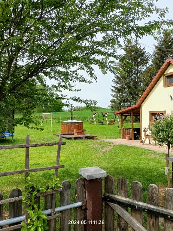 a field with a fence and a playground at Agroturystyka pod świerkami in Ryn