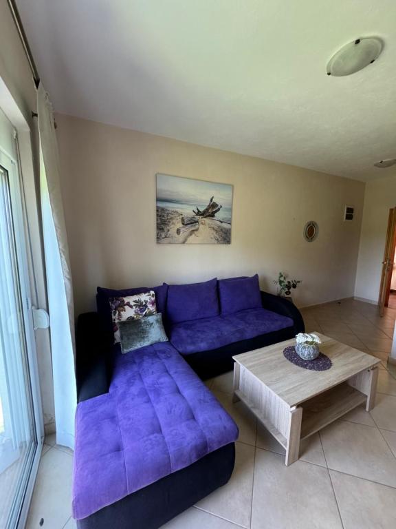 a living room with a purple couch and a table at Sunrise house apartments in Ulcinj