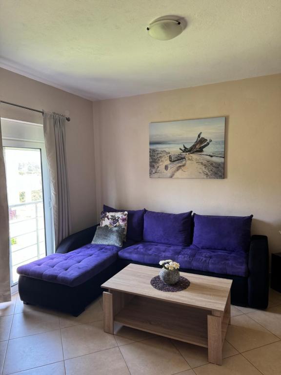a living room with a purple couch and a coffee table at Sunrise house apartments in Ulcinj
