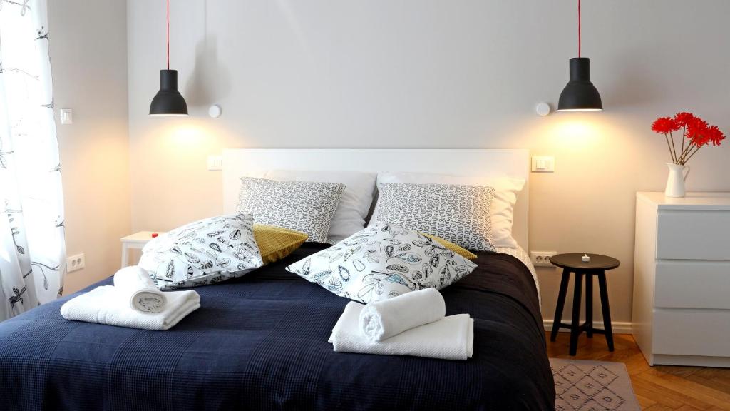 Un dormitorio con una cama azul con almohadas. en Park and Bike City Studio Zagreb, en Zagreb