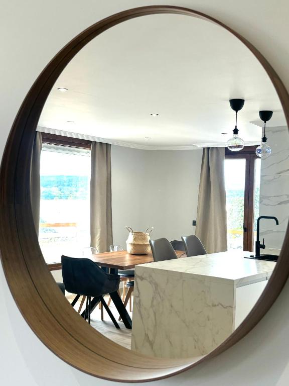 a mirror reflecting a dining room with a table and chairs at Piso Playa de Los Barcos in Isla