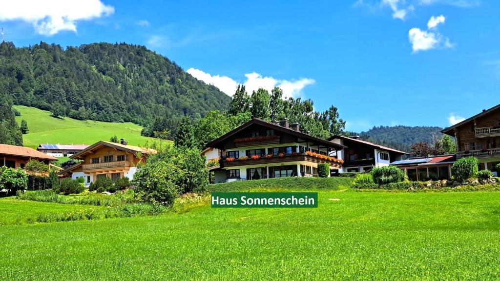 a resort in the mountains with a green field at Ferienwohnung Rosendahl in Reit im Winkl