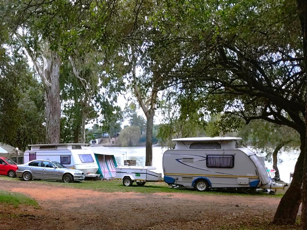 un groupe de tentes et de voitures garées dans un camping dans l'établissement Westvaal Holiday Resort Campsites - Bring your own Tent or Caravan, à Parys