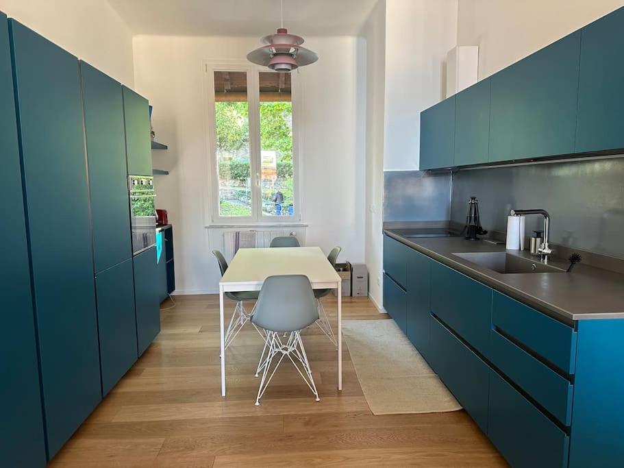 eine Küche mit blauen Schränken sowie einem weißen Tisch und Stühlen in der Unterkunft Un meraviglioso spazio a Camogli in Camogli