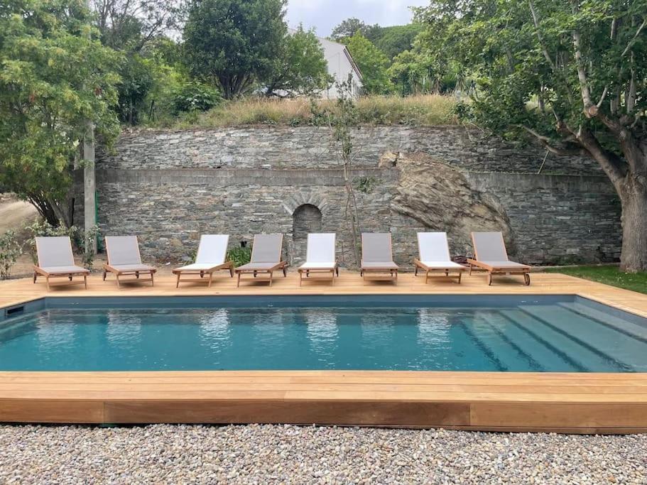 a group of lounge chairs sitting next to a pool at Villa prestige avec piscine - dans les hauteurs de Bastia in Bastia