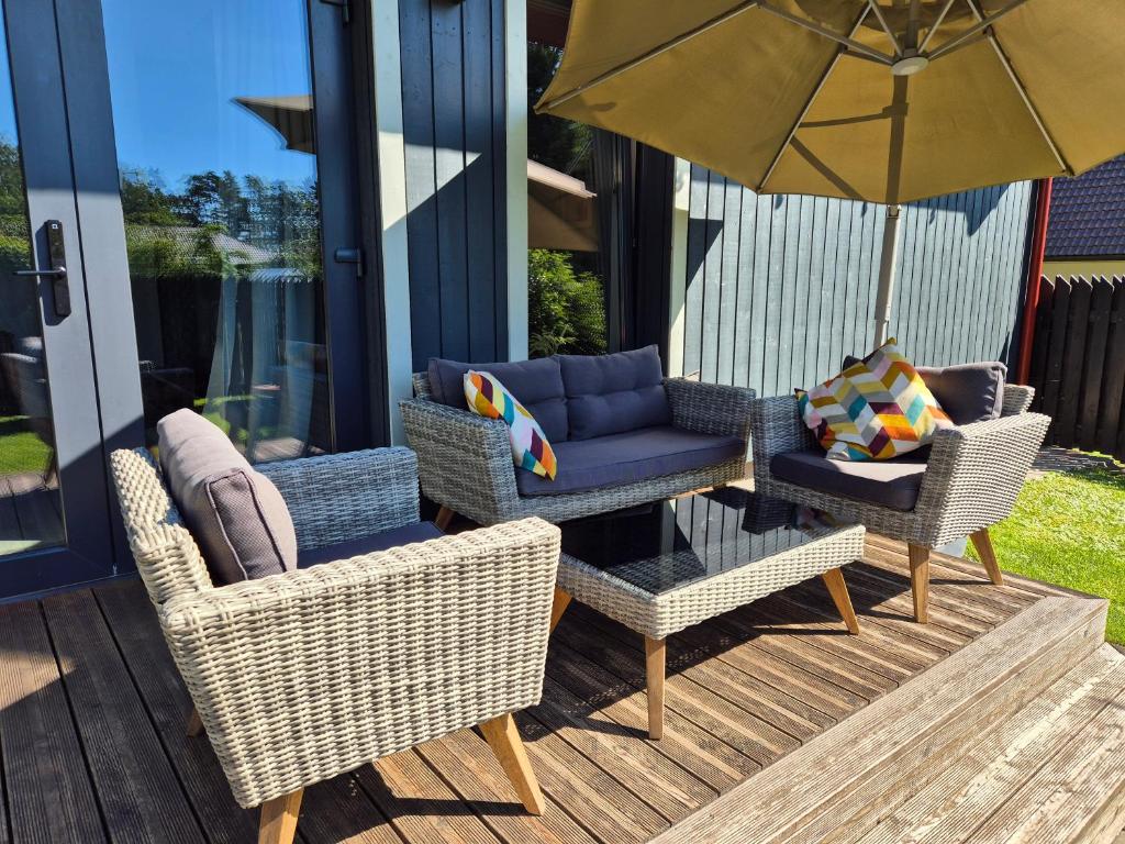 a group of chairs and an umbrella on a patio at atPUUTA in Saulkrasti