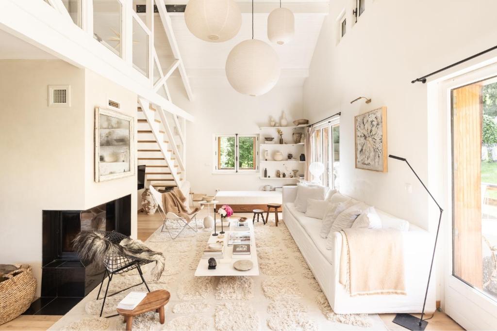 un salon avec un canapé blanc et une cheminée dans l'établissement Chalet Hautbois - Family Chalet with 5 Bedrooms with Glacial views CHAMONIX - By Cozee Rentals, à Chamonix-Mont-Blanc