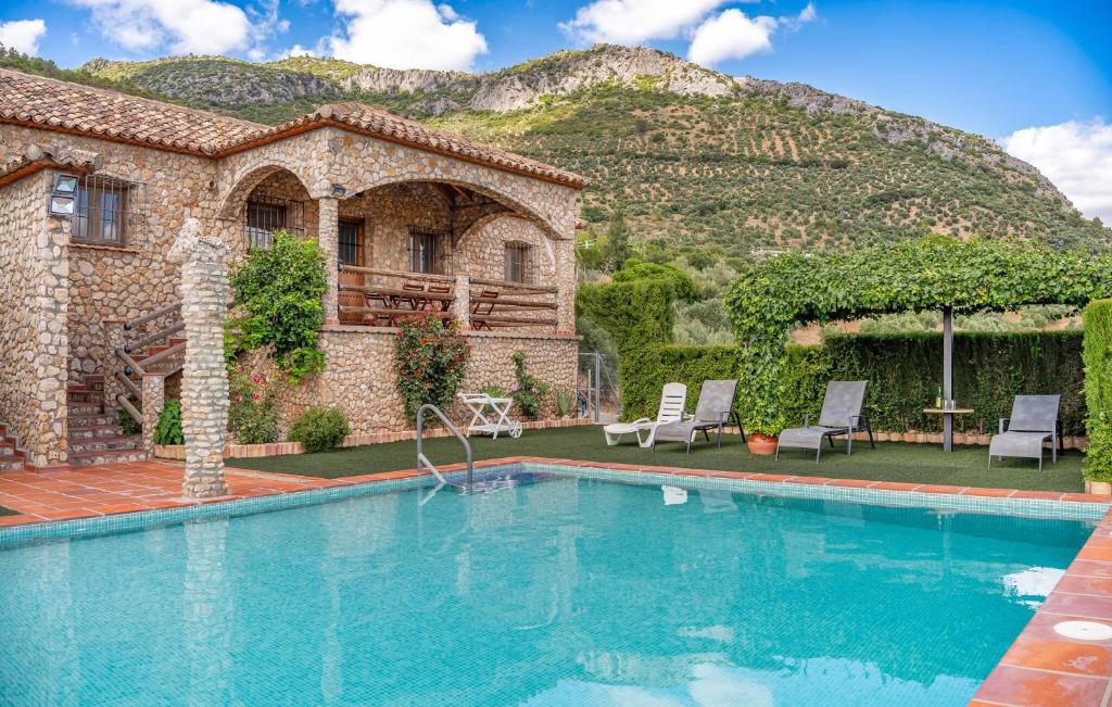a house with a swimming pool in front of a mountain at Lovely Home In Algodonales in Algodonales