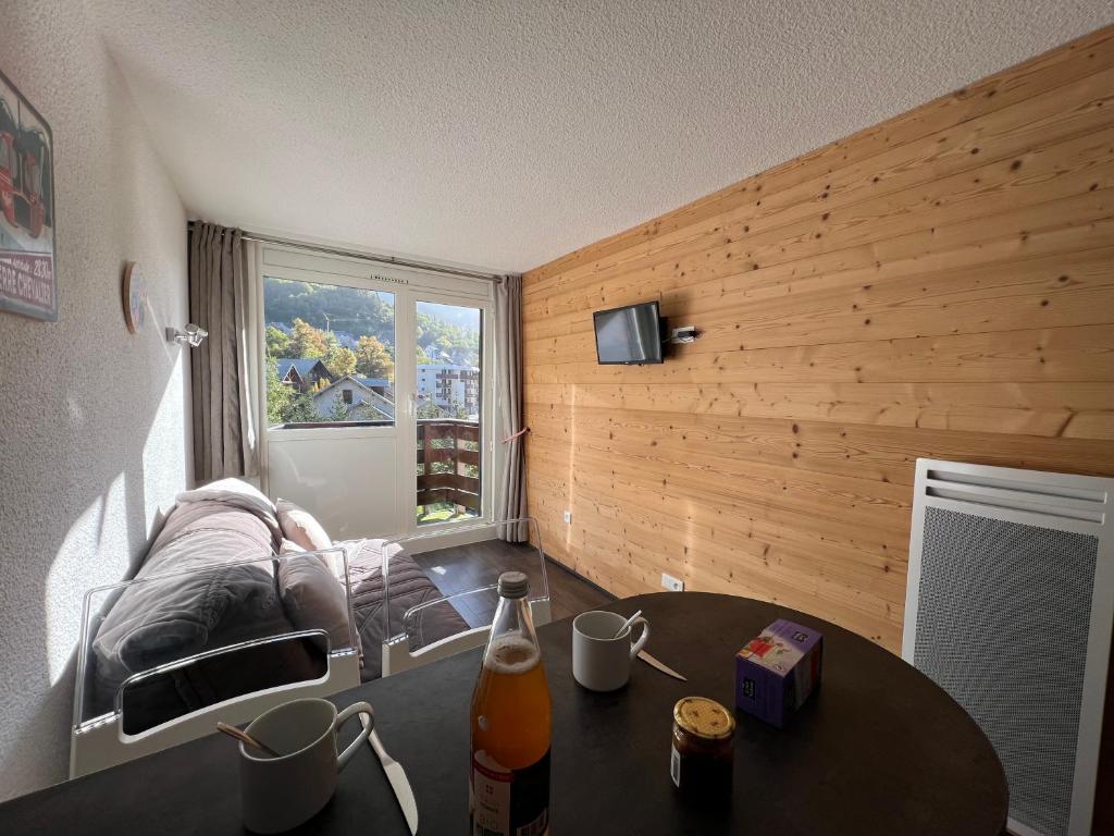 Habitación con mesa, sofá y ventana en Les Mélèzes, en Saint-Chaffrey