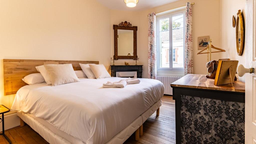 une chambre avec un grand lit blanc et un miroir dans l'établissement Jade - Evasion vintage, à Dijon