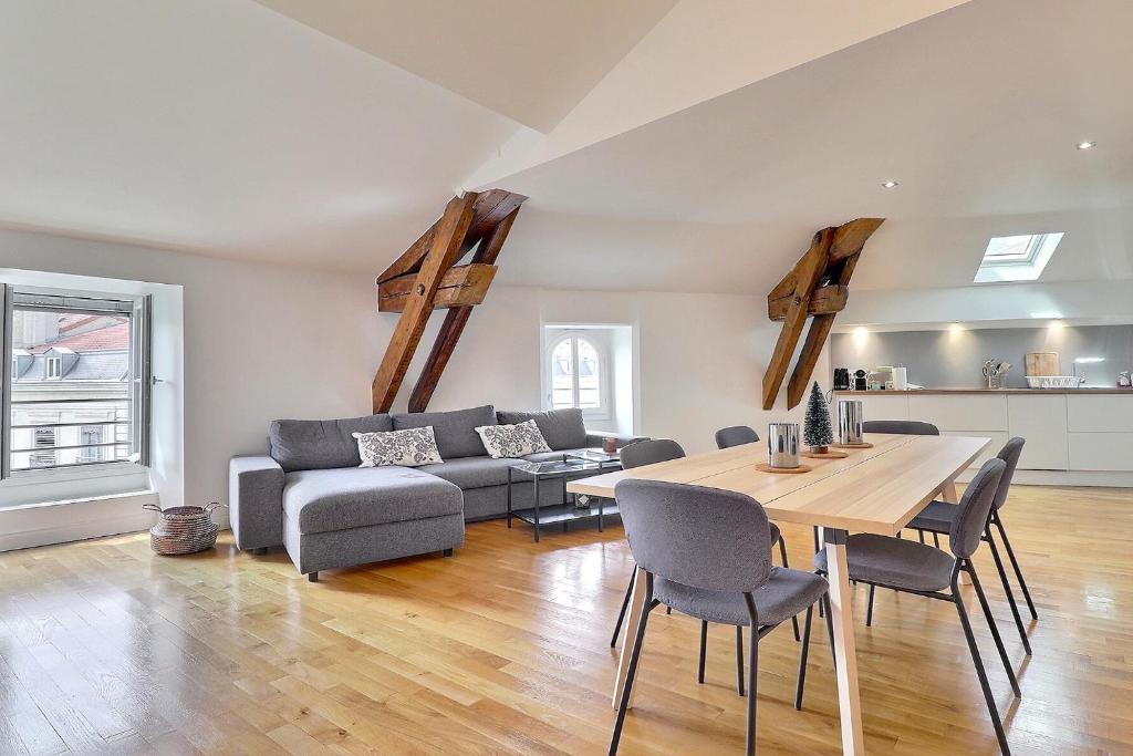 una sala de estar con una mesa y un sofá en Appartement d'exception plein centre, en Lyon