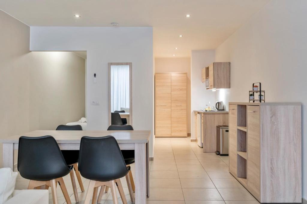 a kitchen with a table and chairs in a room at Ambassador Suites Leuven in Leuven