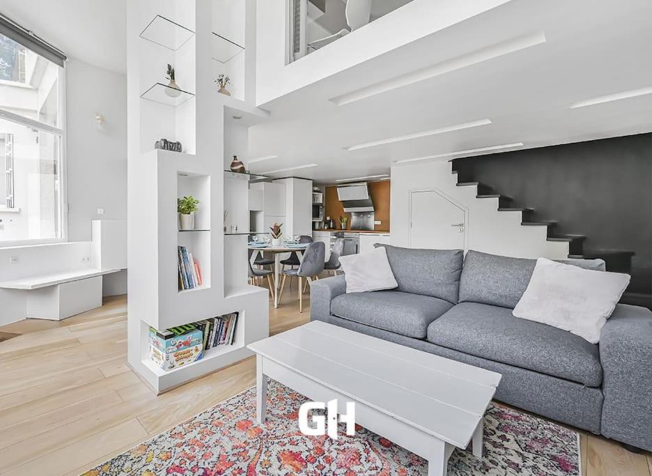 un salon avec un canapé et un escalier dans l'établissement Le 21 - Appart 4P 2BDR - Proche Paris - Wifi, à Saint-Maur-des-Fossés