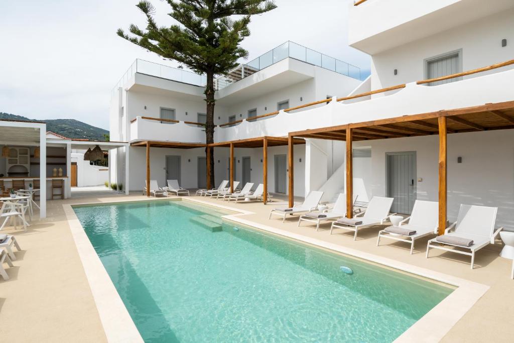 an external view of a villa with a swimming pool at Aspronissos Hotel in Skiathos