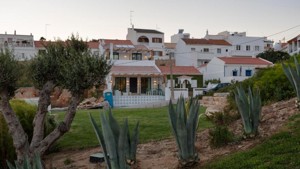 a group of houses in the background with plants at Casas da Praia by Sevencollection in Salema