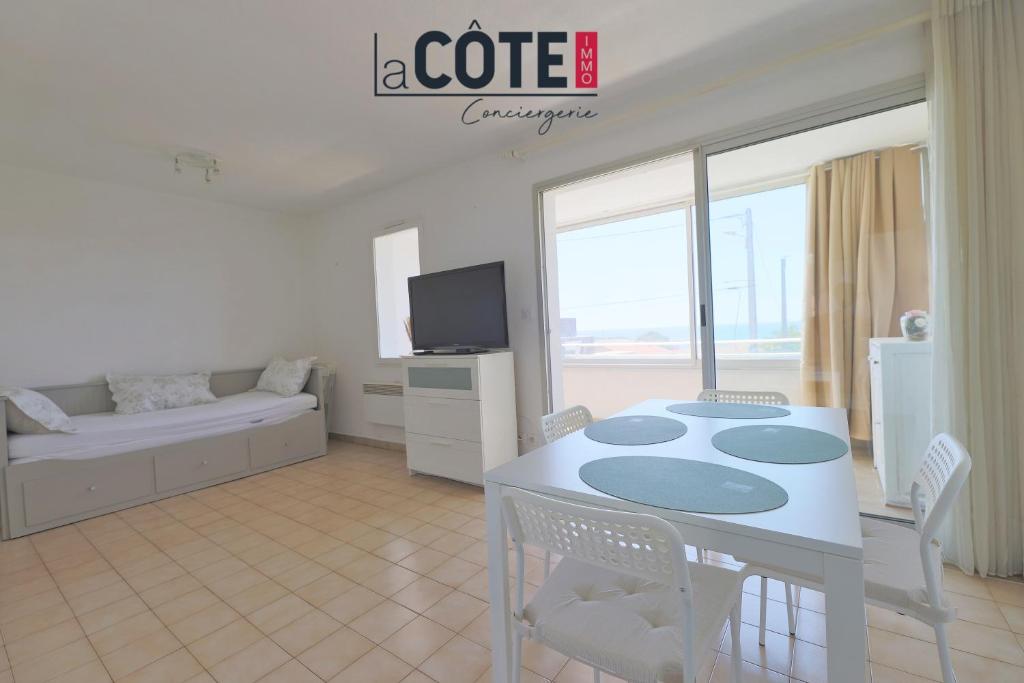 une table blanche et des chaises dans un salon dans l'établissement Le baoucailla, à Martigues