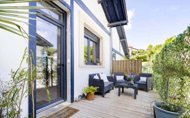 eine Terrasse mit Sofas und Stühlen auf einem Haus in der Unterkunft Loft Frontière Montagne et Plage in Urrugne