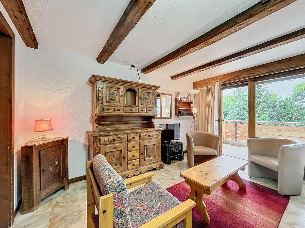 a living room with a large wooden cabinet and a table at Cimerose 1 in Verbier