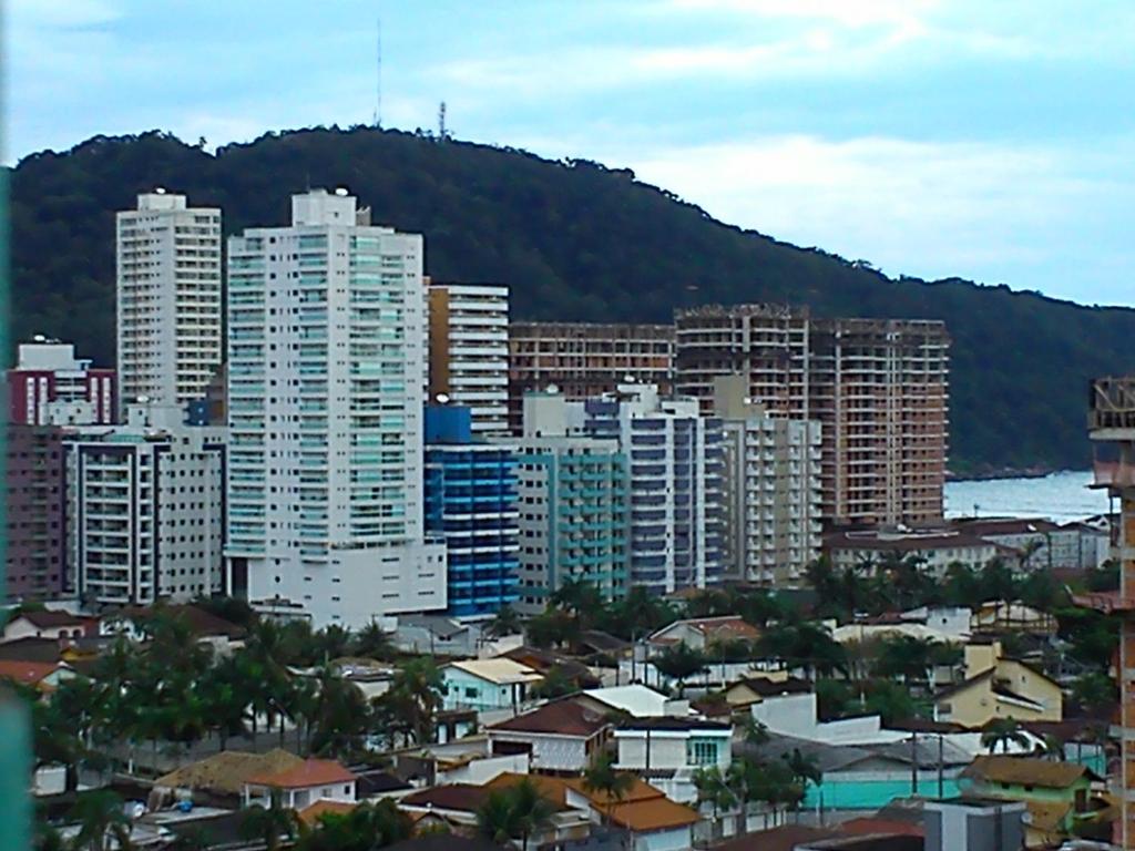 una città con edifici alti di fronte a una montagna di Apartamento Canto do Forte a Praia Grande