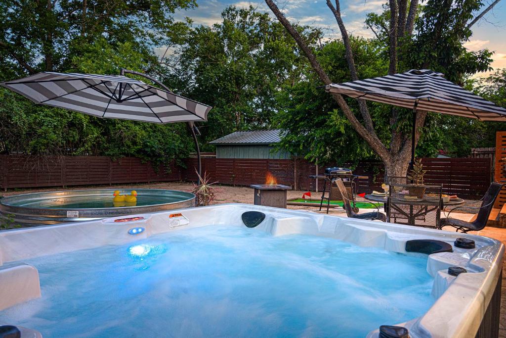een hot tub met parasol in de achtertuin bij Cava House, Hot tub, Cowboy Pool, Fire pit! in Fredericksburg