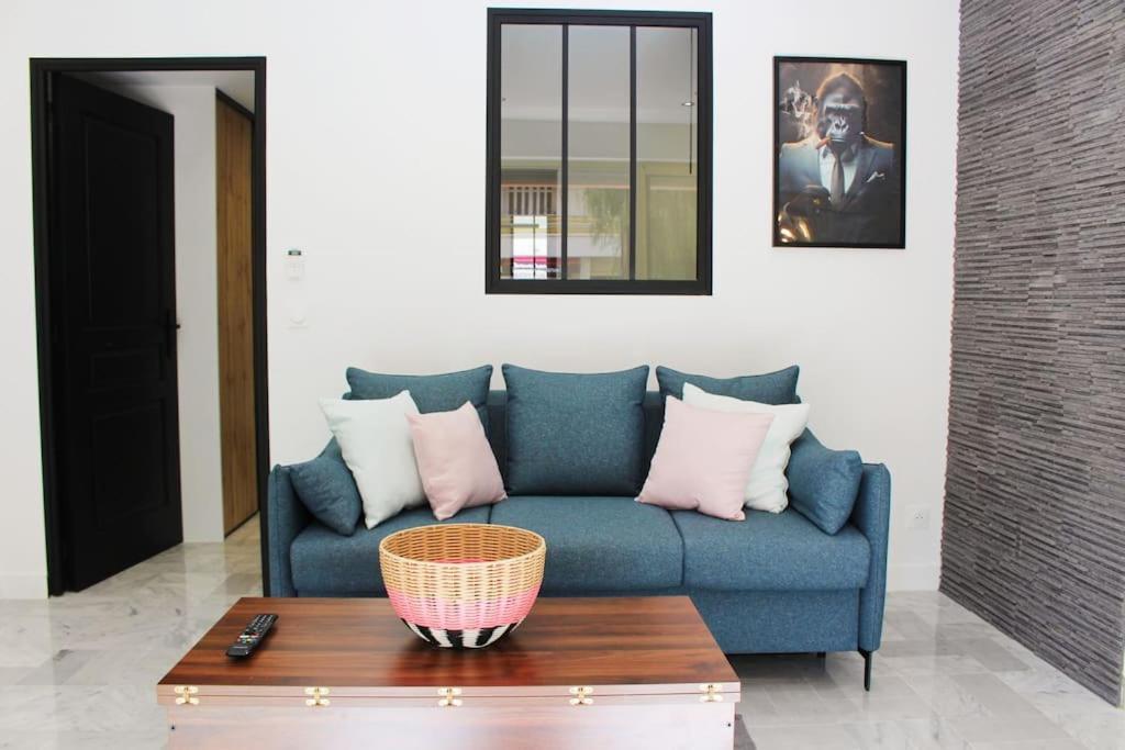 un salon avec un canapé bleu et une table dans l'établissement Lucky, centre-ville, à 10 min à pied des plages Antibes et Juan les Pins, à Antibes