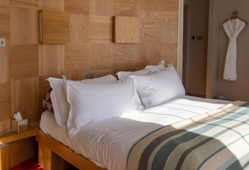 a bedroom with a bed with white sheets and pillows at Drakes Hotel in Brighton & Hove