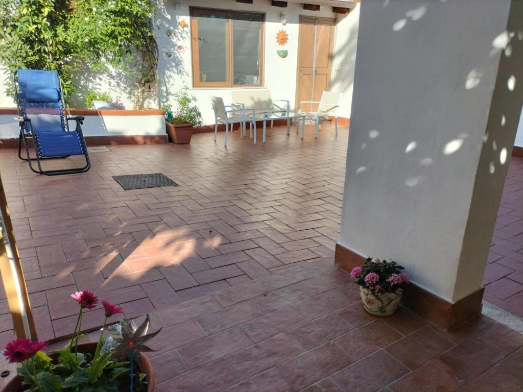 een patio met een blauwe stoel en een tafel en stoelen bij Green Space Apartment in Mondello